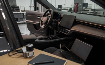 Unbranded car dashboard and engineering bench showing built-in infotainment reliability testing
