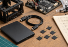 Generic microSD cards, portable SSD, USB-C cable and robot controller arranged on a workshop bench