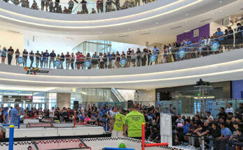 Official RECF robotics competition event photo showing teams, fields, and spectators