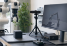 Robotics simulation workstation with robot arm, depth-camera rig and neutral rendered test scene