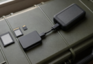 Unbranded memory cards, a card reader and a portable SSD arranged in a field case.