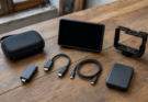 A field video kit with capture dongle, HDMI cable, USB-C cable, monitor and camera cage.