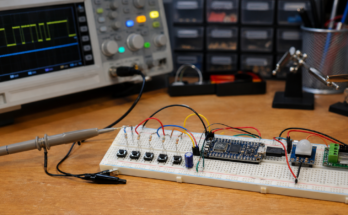 A pushbutton debouncing test bench with microcontroller, oscilloscope probe and tidy wiring.