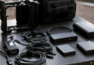  unbranded USB-C cables, portable SSDs, dock, camera cage, cable tester and battery pack, natural daylight, no logos, no read