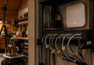  wall-mounted access point, Ethernet patch panel, robot cart, camera tripod and labeled cable tags that are not readable, war
