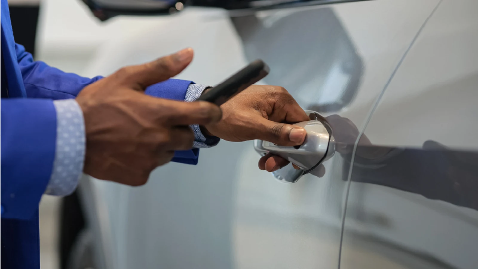 Smartphone held near a vehicle door handle for digital access
