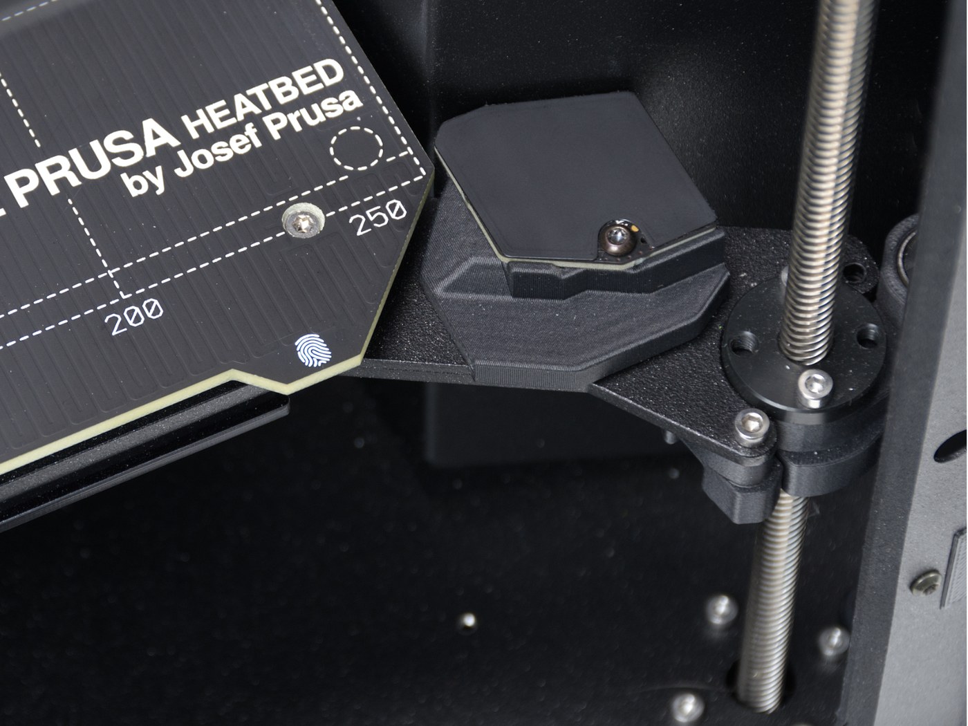 Official Prusa INDX hardware detail photo showing the heated bed area and nearby toolchanger mechanism