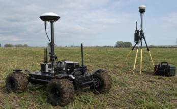 Small field robot RTK correction test with GNSS antenna, radio module, LTE modem, and base station tripod