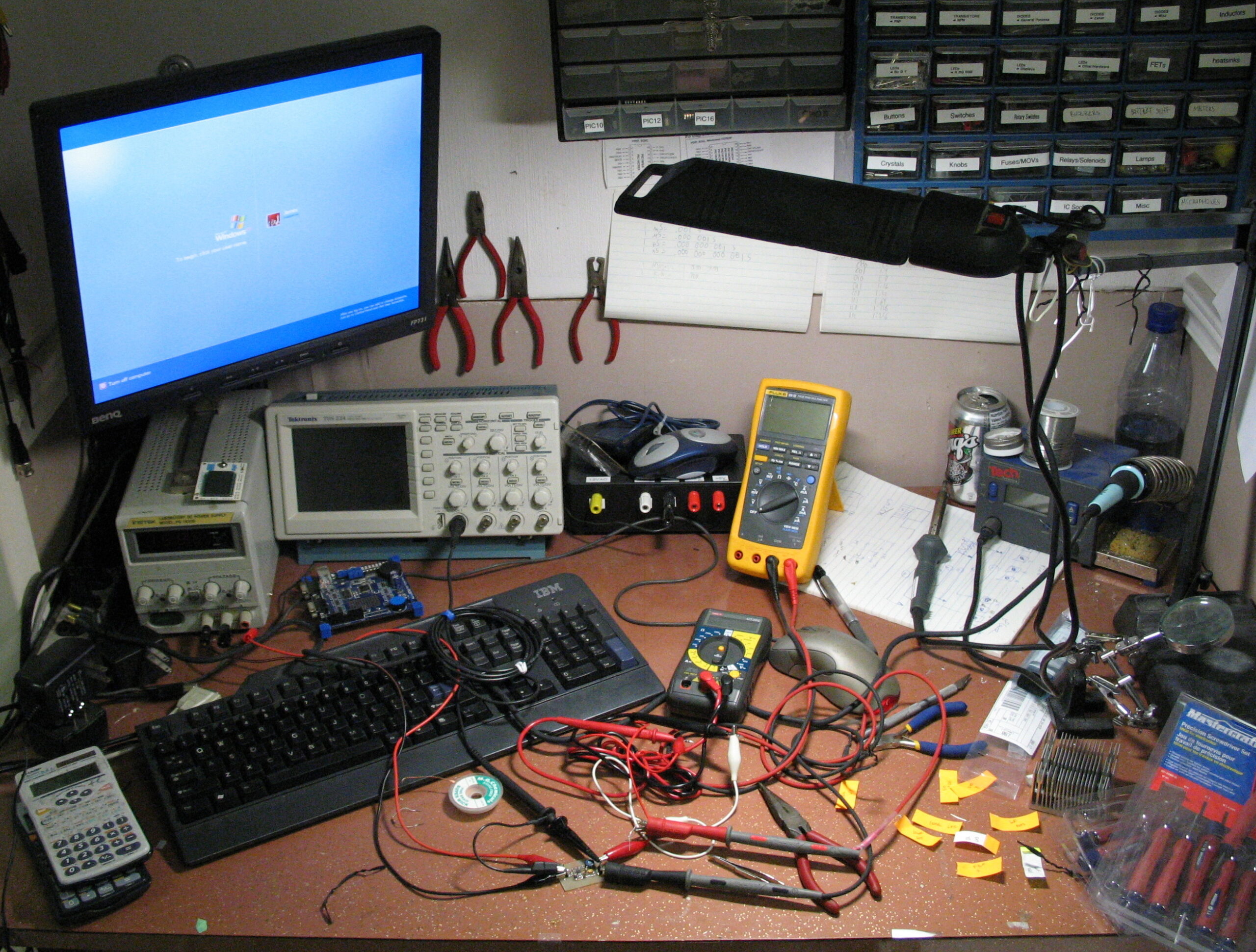 Electronics workbench with oscilloscopes, meters and bench instruments.