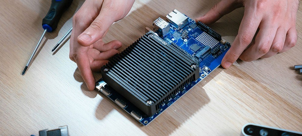 Hands installing an Arduino board with a large heatsink