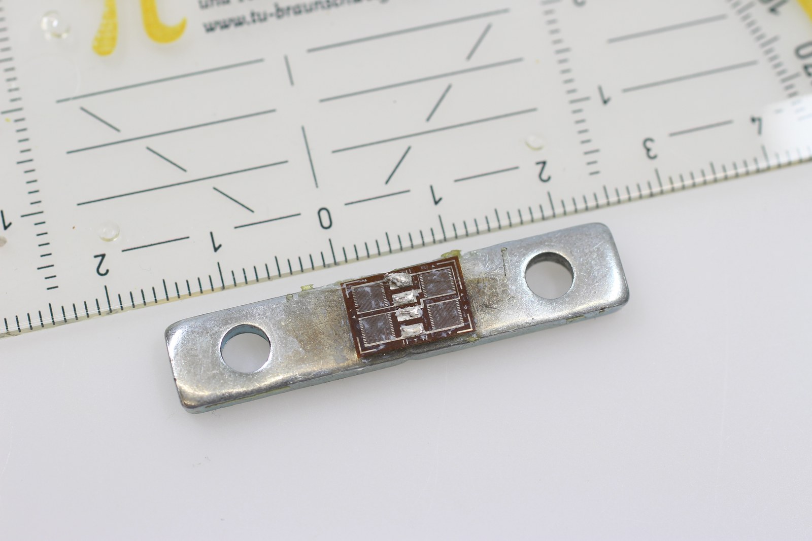 Metal bar load cell showing its machined flexure and cable