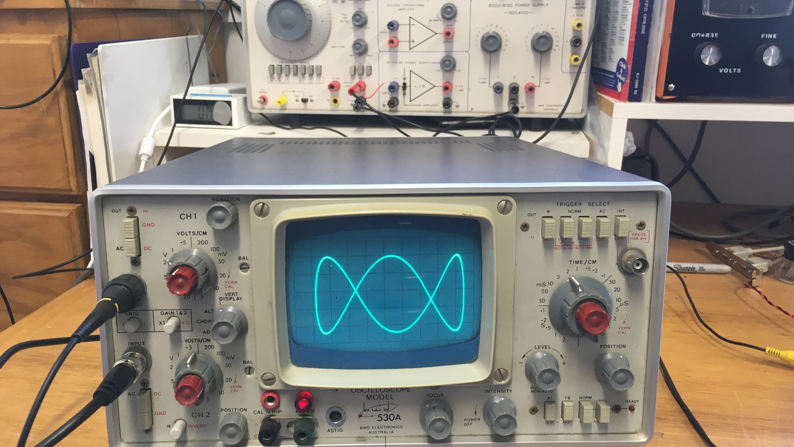 Bench oscilloscope beside electronics laboratory equipment