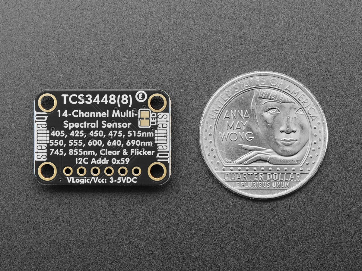 Back of the Adafruit TCS3448 breakout beside a quarter for scale