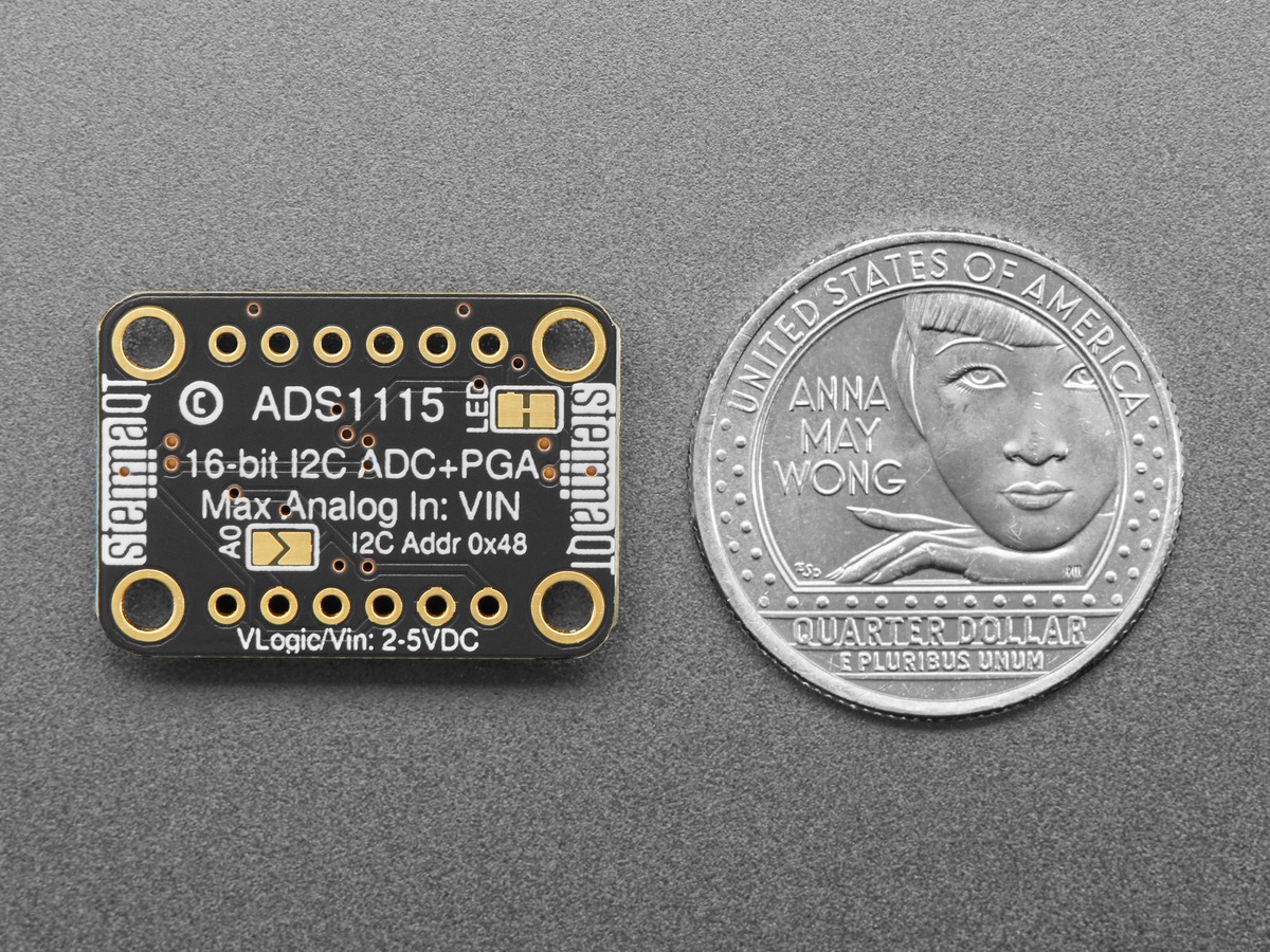 Back of an Adafruit ADS1115 breakout beside a coin, with the input-limit and address table visible