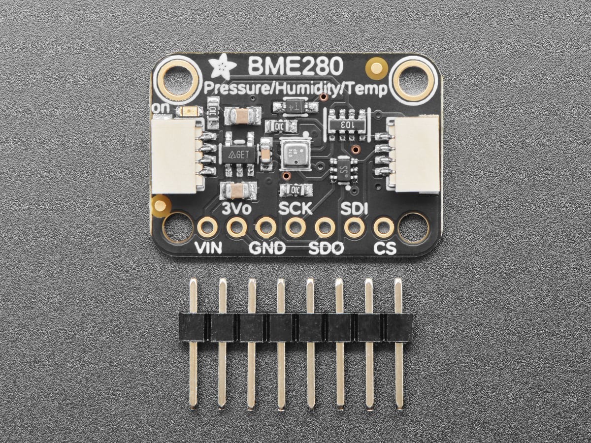 Adafruit BME280 breakout beside its loose header pins