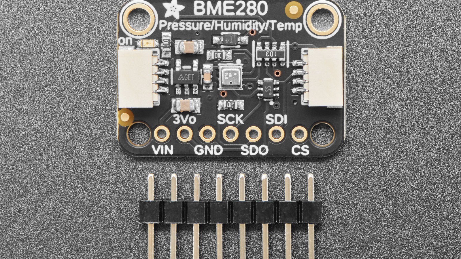 Adafruit BME280 breakout beside unsoldered header pins